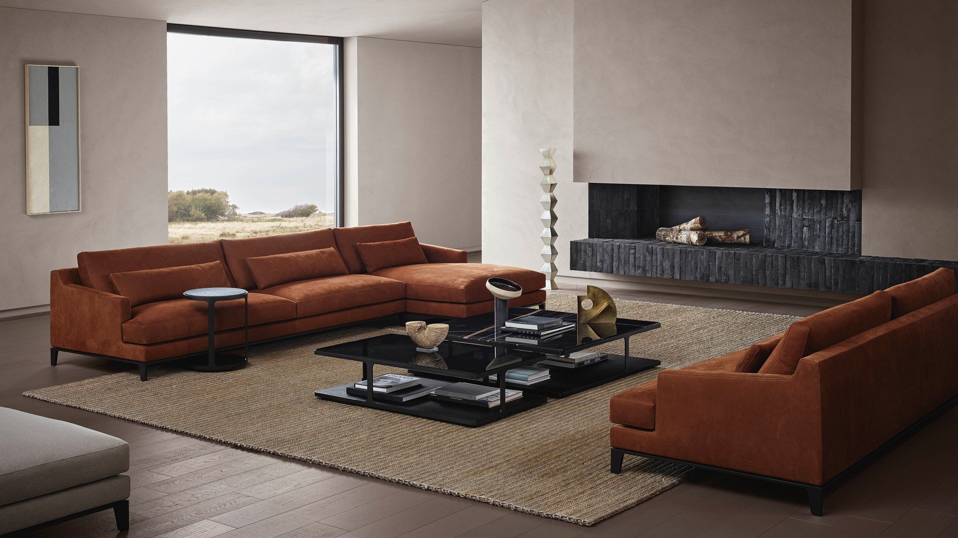 Bellport sofas in removable leather Nabuk 09 ruggine, cushions with decoration and lower back cushion in leather Nabuk 09 ruggine, cushions in velvet Persia 1404 carbone, feet with profile in mat brown nickel. In the center, Creek coffee tables, square version with upper top in glossy marble sahara noir, rectangular version with upper top in fumé glass, lower shelves in black elm and mat brown nickel structure. Next to the sofas, round Creek coffee tables with top in black elm, lower shelf in black elm and brushed brown nickel structure. Rectangular Creek coffee table with top shelf in fumé glass and lower shelf in moka glossy lacquered, brushed brown nickel structure.