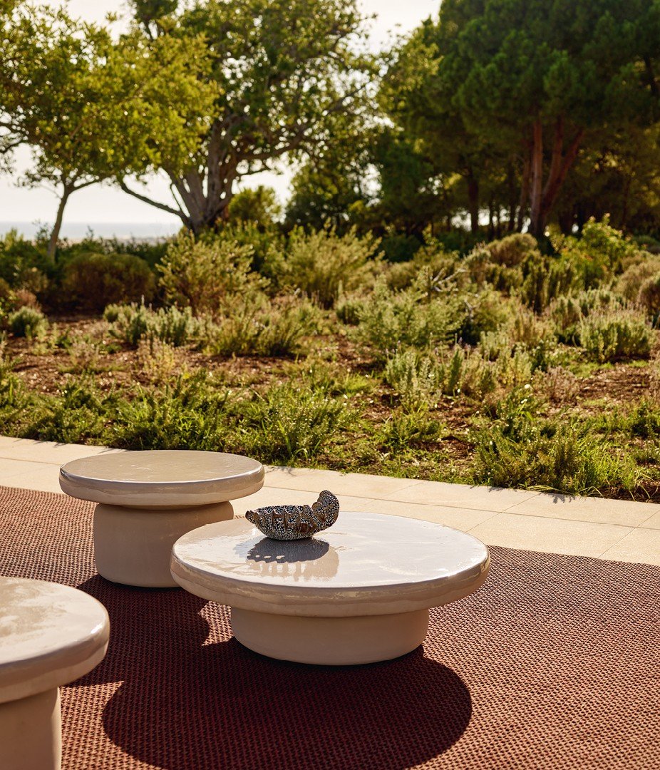 Crew coffee tables in mat glazed gres sabbia with glossy glazed top and upper part of the edge. Carpet Kamir mattone.