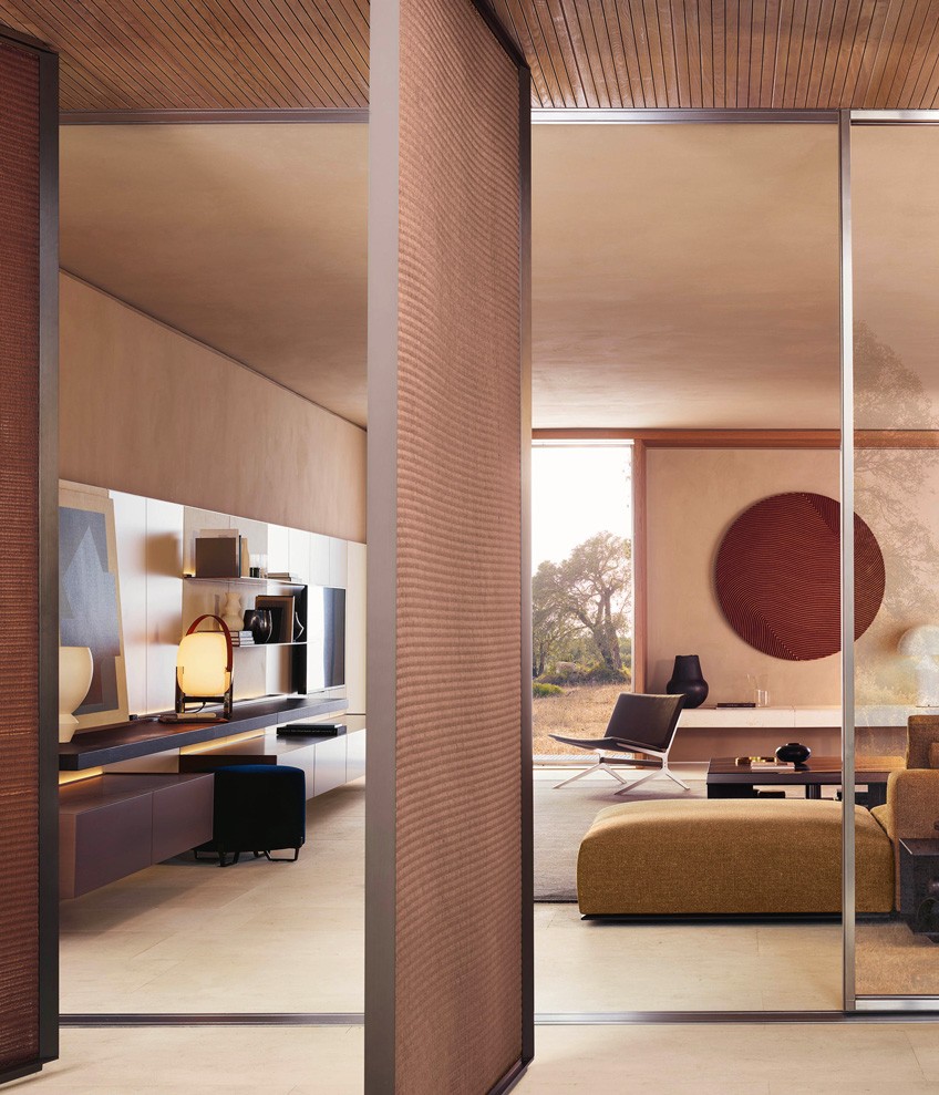 Composition of wall-mounted Code storage units. Doors with bronze metal lacquer finish. Handle with matt slate finish; in reflective transparent glass, frame and handle with matt slate finish. Backlit top and side panels with bronze metal lacquer finish. Open compartments and structure with bronze matt lacquer finish. Walls of open compartments and TV stand in Gold oak, walls of storage units with shelves covered in light linen textile. TV stand with storage units with drop-down doors. Front with bronze metal lacquer finish. Display units with internal transparent glass shelves and drawers with bronze metal lacquer finish. Top in polished Zecevo marble. Integrated LED lighting.