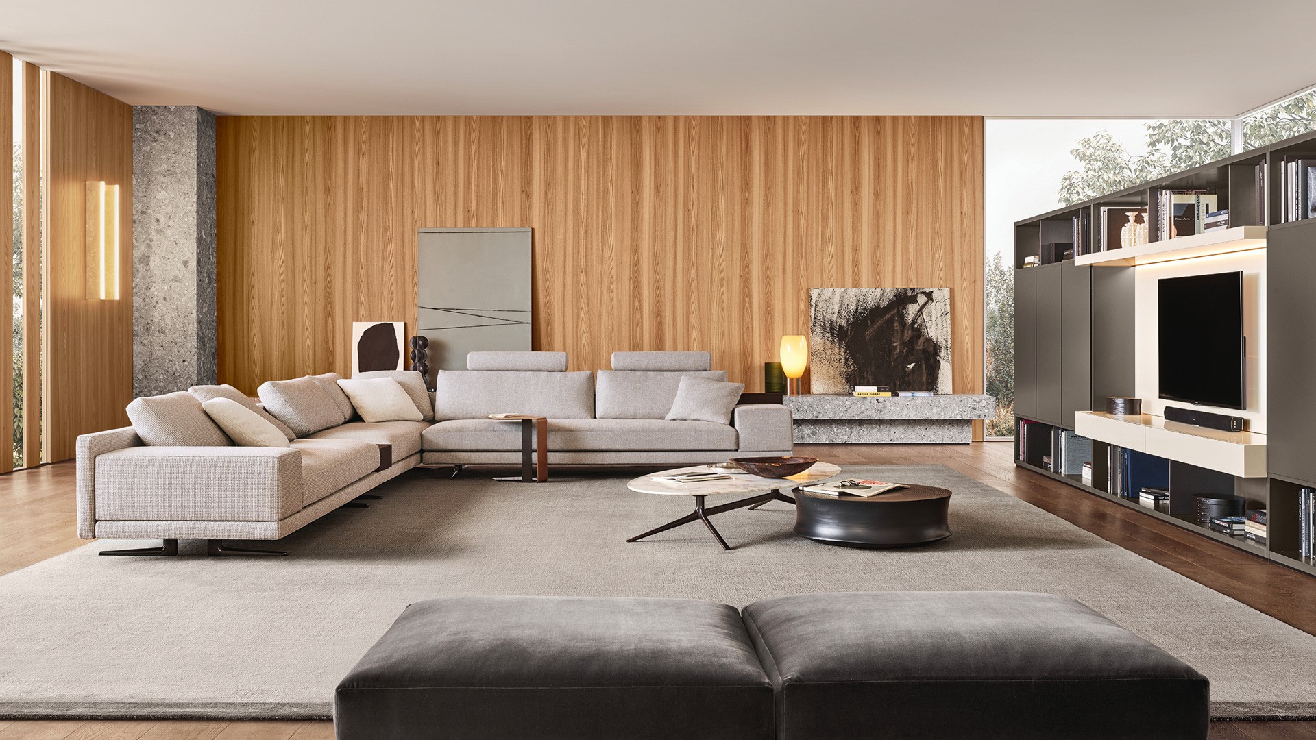 Система корпусных модулей Wall System: структура и распашные двери Slim с лакированной матовой отделкой цвета визоне. Стенки и боковые панели с лакированной металлической отделкой титанового цвета. Стойка для телеаппаратуры с лакированной матовой отделкой цвета канапа и откидной дверью Jet. Встроенная светодиодная подсветка. Диван Mondrian, съемный чехол из ткани Zante цвета корда (12), подушки из ткани Sparta цвета крем (18). Ножки с никелированной глянцевой отделкой Brown Nickel. В центре: журнальный столик Mondrian с овальной столешницей из матового мрамора Calacatta Oro и глянцевой структурой с никелированной глянцевой отделкой Brown Nickel. Журнальный столик Soori из металла с отделкой под антикварную бронзу. Пуф Mondrian, съемный чехол из бархата Persia цвета карбоне (1404). Ножки с никелированной глянцевой отделкой Brown Nickel.
