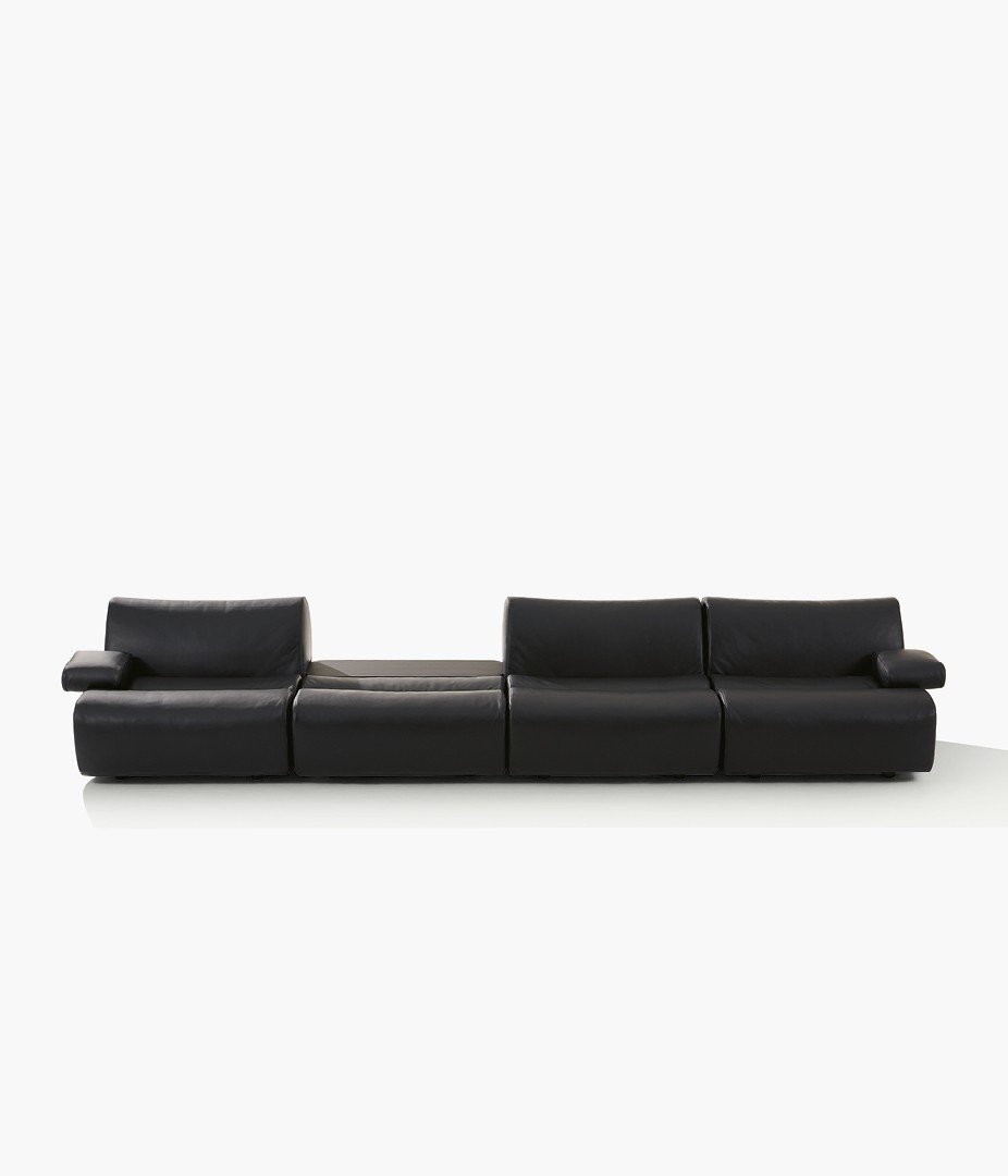 Ernest sofa with removable cover in leather Natural 10 nero, behind sofa coffee table in black elm.