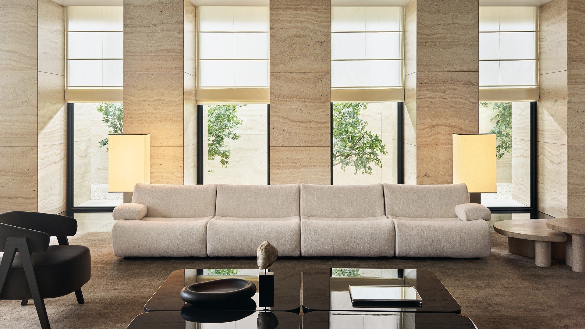 Ernest sofa in removable fabric Shedir 02 burro. Loai armchairs in removable velvet Persia 2002 bruciato, structure in black elm. Ernest coffee tables in glossy lacquer moka and mat marble travertino classico. Carpet Shindo natural.