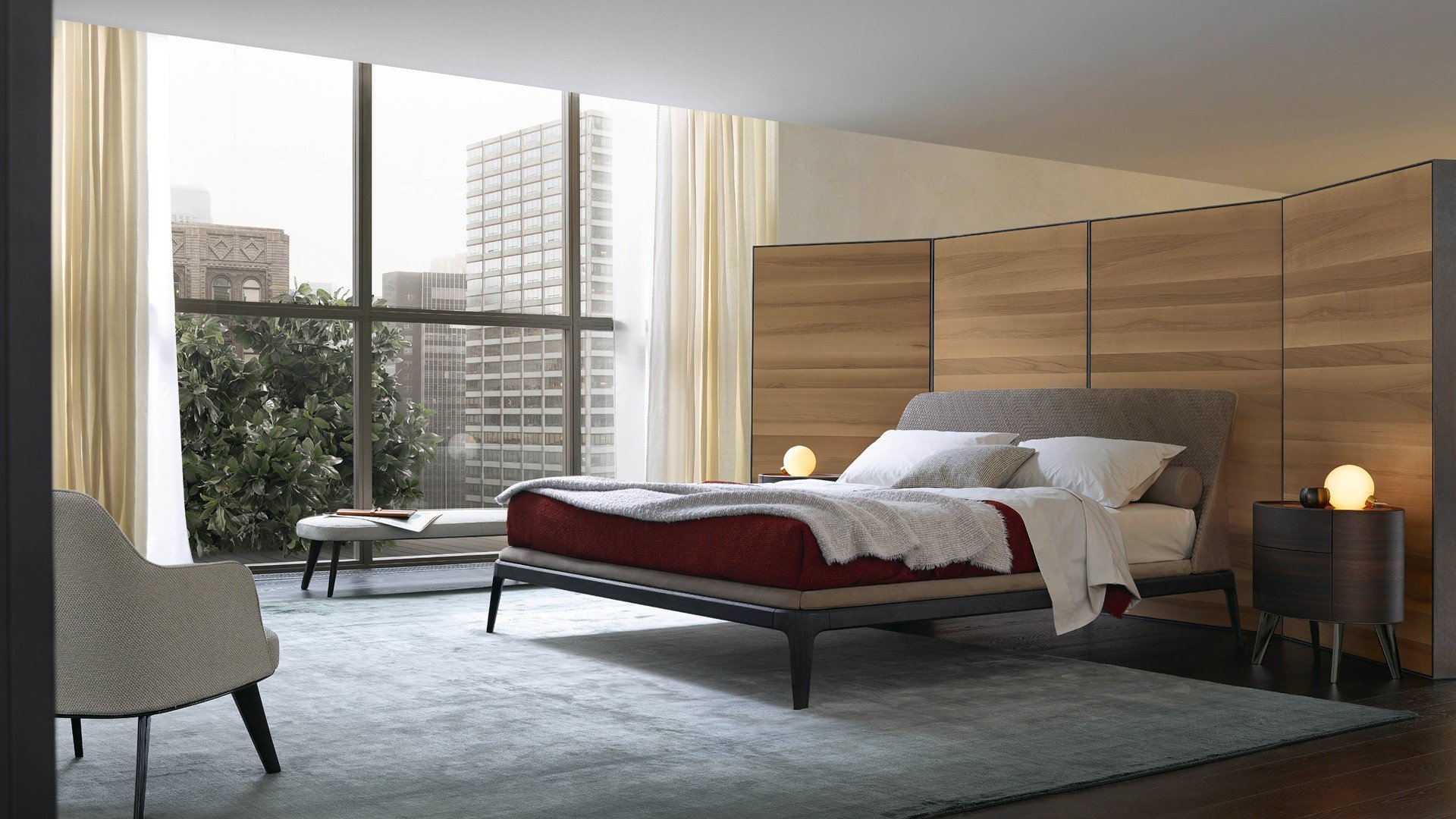 Kelly bed, padded headboard with non-removable covering, outer part in leather Nabuk 02 tortora, inner part in woven leather Nabuk 02 tortora. Bed frame in spessart oak and inner part with non-removable covering in leather Nabuk 02 tortora. Matching bed linen in cotton Provence 08 polvere with profiles in bianco and polvere. Kelly night tables in spessart oak with ginger glossy lacquered top and feet in glossy brown nickel. Jane armchair and bench in removable fabric Paros 06 arena, base in glossy brown nickel. Senzafine Bangkok wardrobe in hide 28 avorio and integrated Quid with wall panelling in black elm. Carpet Soft.
