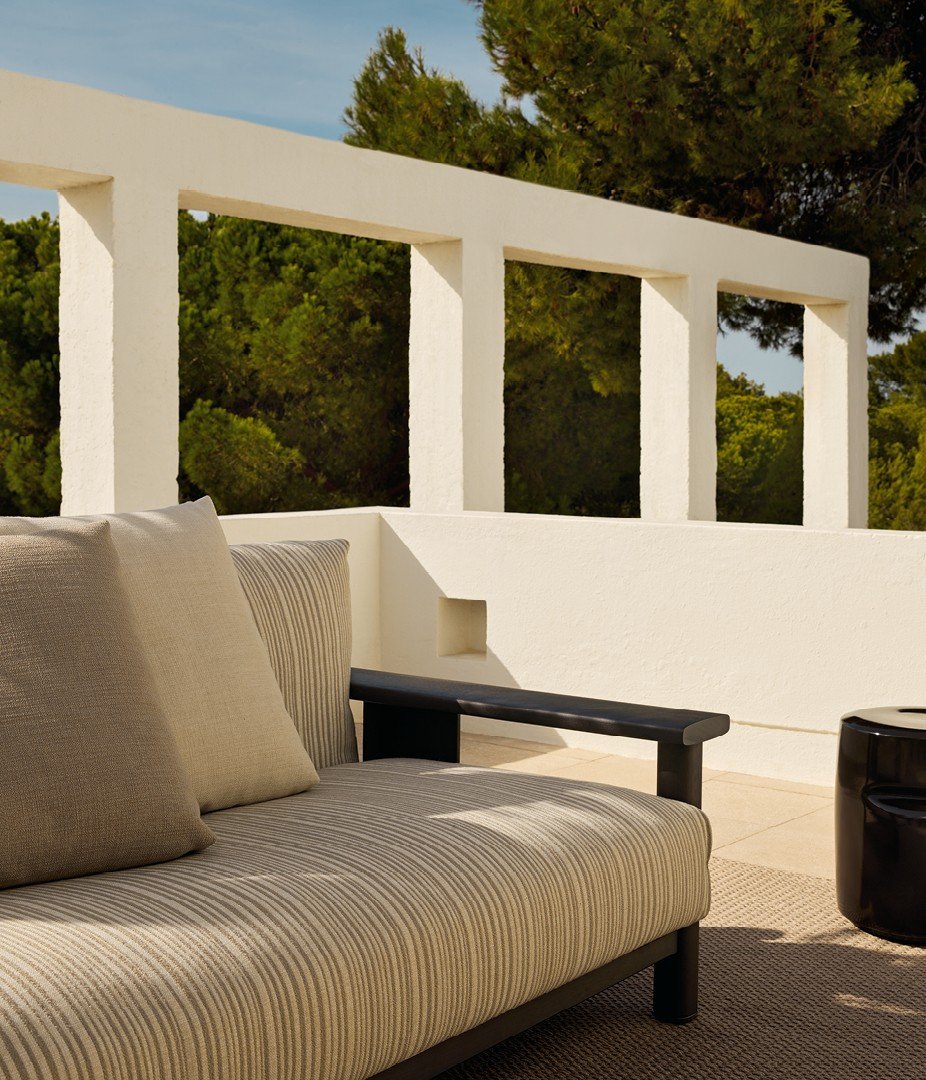 Ketch sofa with structure in solid black stained iroko and backrest in EVA ghiaccio, removable cover in fabric Ghibli 04 sabbia with decorative drawstring stitching, cushions in fabric Karif 02 burro and 03 sabbia.
