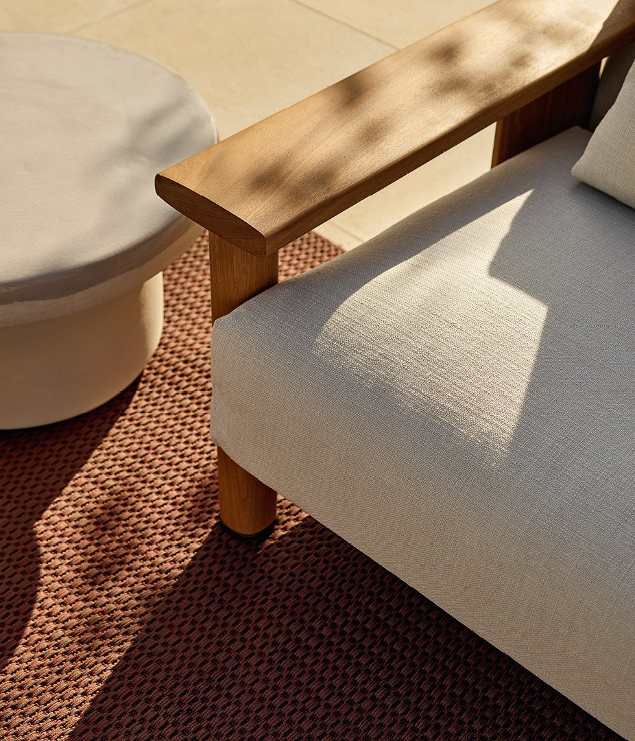 Ketch sofa with structure in solid teak and backrest in EVA ghiaccio, removable cover in fabric Karif 02 burro with decorative drawstring stitching, cushions in fabric Karif 02 burro and 03 sabbia.