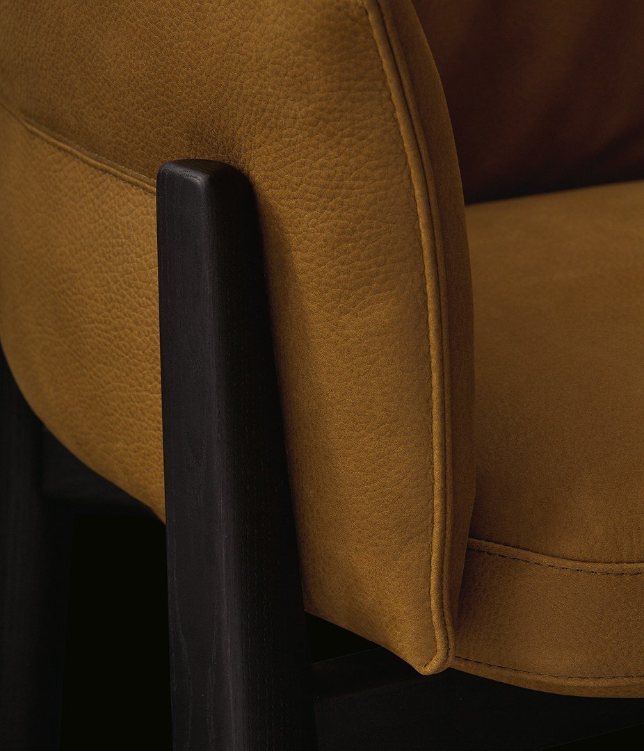 Қара қарағай құрылымы және senape түсті Silk 12 теріден жасалған алмалы-салмалы жаппасы бар Leopold орындығының жақын түсірілімі.