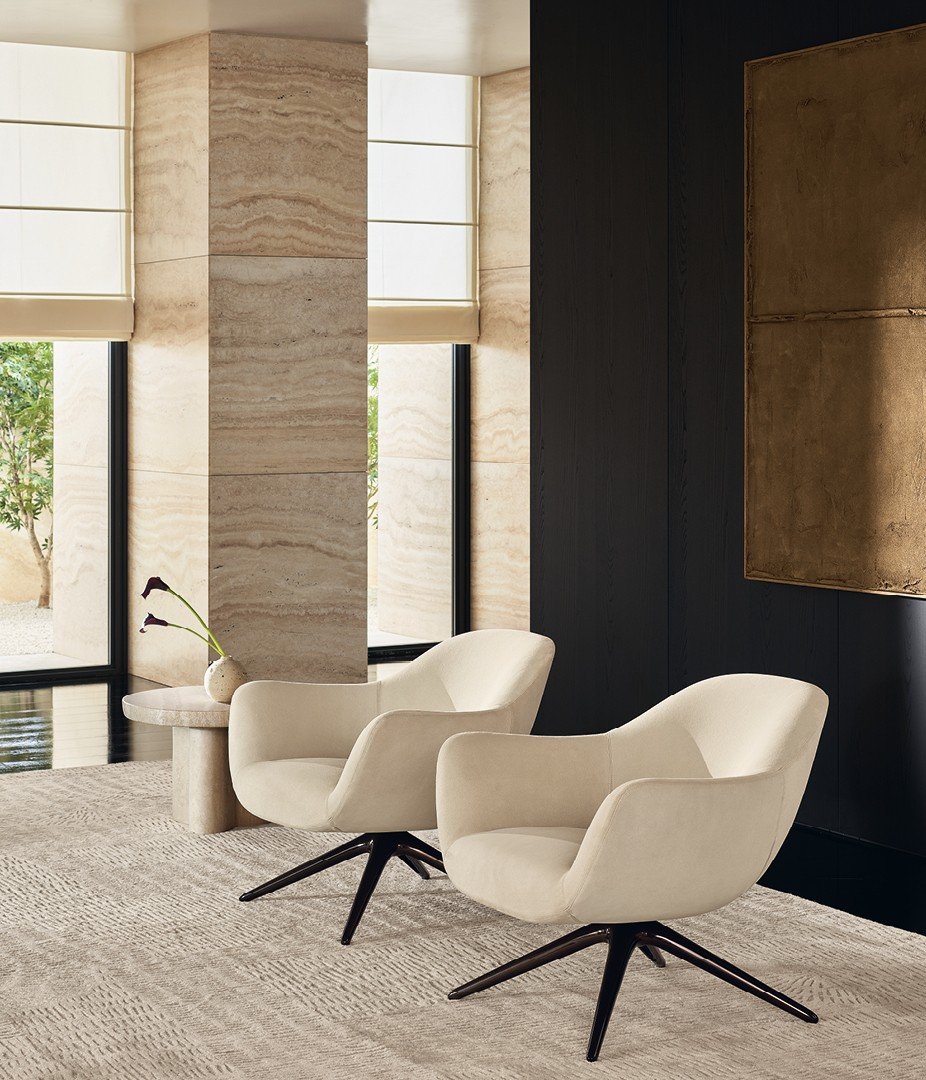 Кресла Mad Chair в съемной коже Suede 01 avorio, поворотное основание из глянцевого темного прозрачного материала. Журнальные столики Ernest из матового мрамора travertino classico. Настенные панели Surface из черного вяза с матовыми профилями ardesia. Ковер Trace белый.
