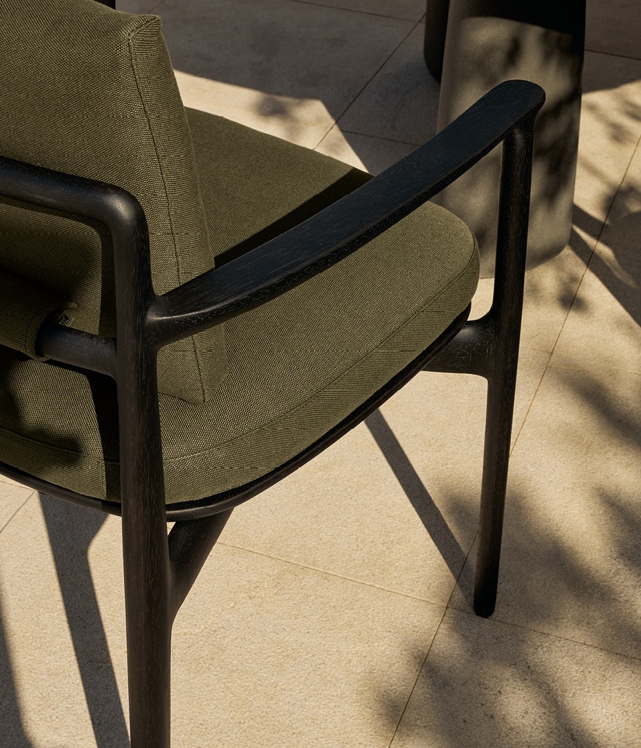Close up of the Magnolia chair with structure in solid black stained iroko, removable cover in fabric Merak 106 bosco.