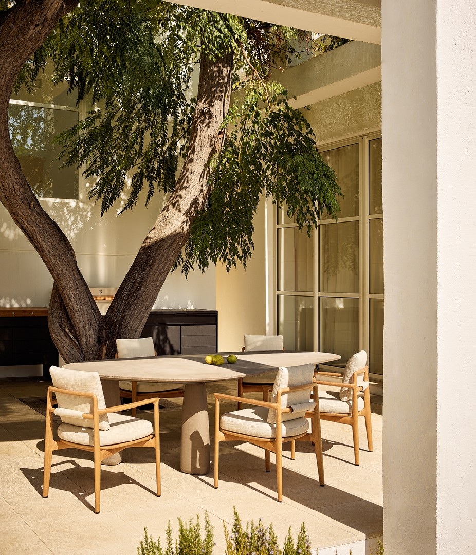 Monolith table with top and legs in Cementoskin® tortora. Magnolia chairs with structure in solid natural iroko, removable cover in fabric Karif 02 burro.