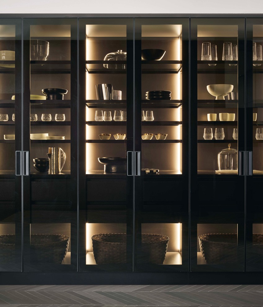 Tall units PR22 with fumé glass doors, black anodized profile and integrated black painted handle. Inside, glass shelves with black anodized aluminium frame and integrated led lighting.