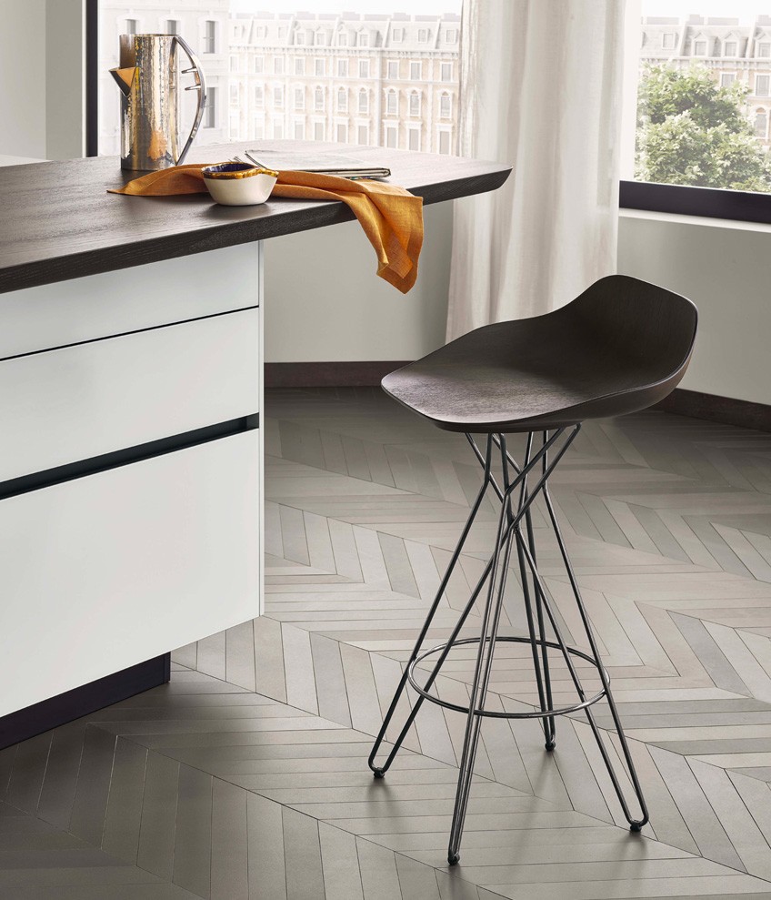 Base units with doors, drawers and pull-out storage baskets in bianco extralight frosted glass, sides and top in dekton bianco. On the base units is the Sydney snack top in solid wood stained black elm. Harmony stool with seat in spessart oak and black chrome structure.