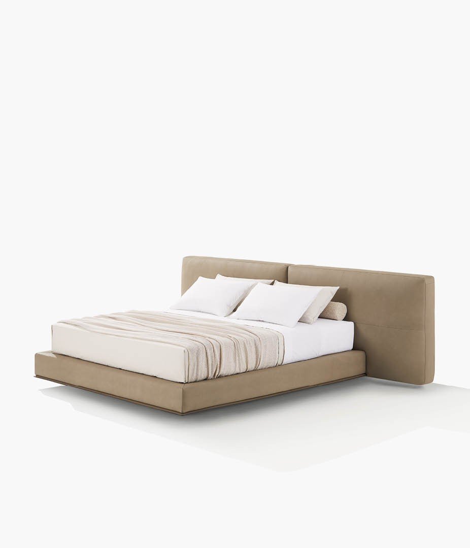 Кровать Brera со съемным чехлом из кожи Silk 02 бежевый, основание из кожи 08 fango и матовые коричневые никелевые ножки. Валики-подушки в съемной ткани Brest 12 sabbia. Координированное постельное белье из хлопка Provence 02 panna и 08 polvere. Плед Linus corda.