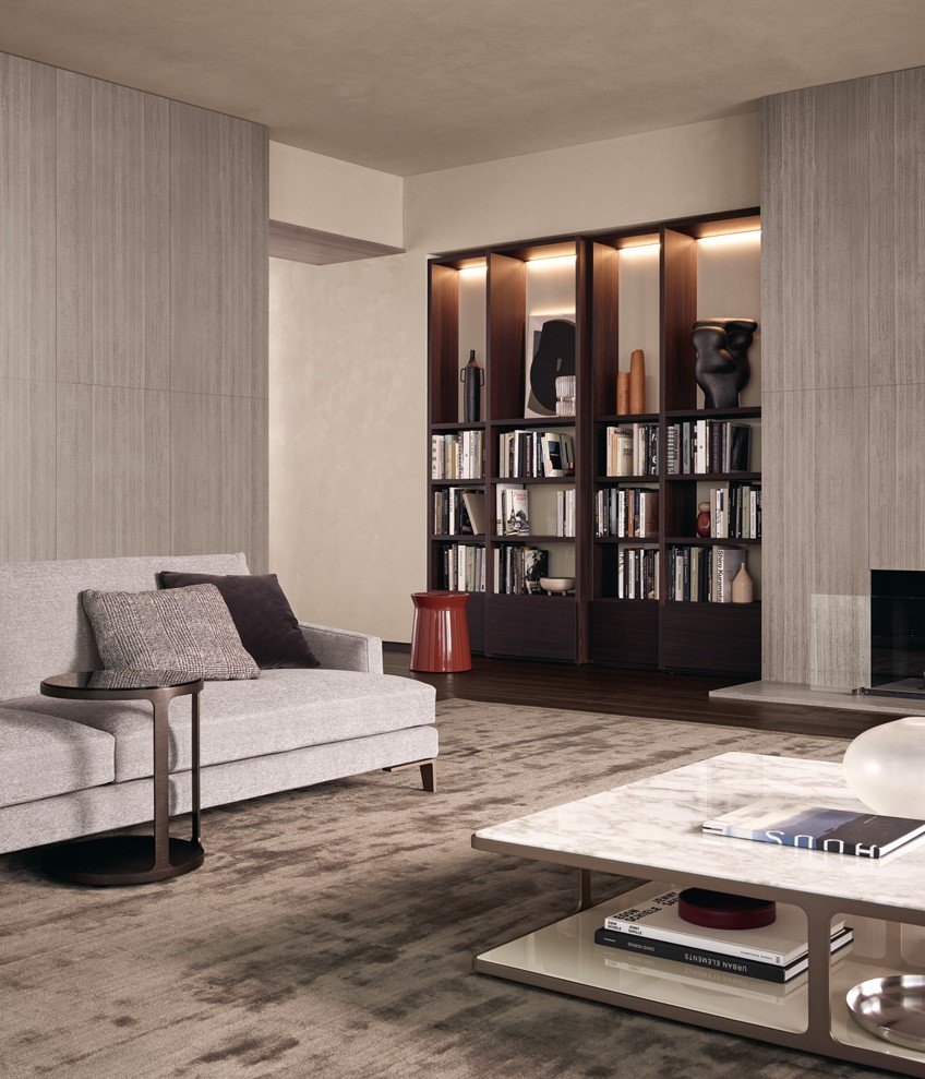 Система корпусных модулей Wall System, структура, полки и ящики Slim из дуба шпессарт, стенки с лакированной глянцевой отделкой цвета канапа. Встроенная светодиодная подсветка. Журнальный столик Dama с лакированной глянцевой отделкой цвета гранат. Диван Bellport со съемным чехлом из ткани Naxos цвета цемент (07). Подушки из ткани Sendai цвета фанго (03) и бархата Persia цвета карбоне (1404). Ножки с матовой отделкой цвета шампанское. Рядом с диваном расположен журнальный столик Creek со столешницей из дымчатого стекла и нижней частью из черного вяза. Структура с никелированной сатинированной отделкой Brown Nickel. На переднем плане: журнальный столик Creek со столешницей из полированного мрамора Calacatta Oro и нижней плоскостью с лакированной глянцевой отделкой цвета канапа. Структура с сатинированным покрытием цвета шампанское. Ковер Frame серого цвета.