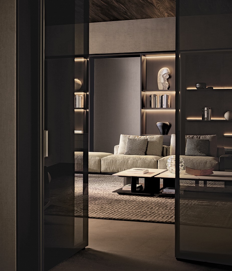 Диван Westside Soft со съемным чехлом из ткани Fushui 01 bronzo и подушками из ткани Janaky 02 champagne. Подлокотник Slim из кожи 08 fango; основание с матовой никелированной отделкой темного цвета. Кресло и пуф Kay Lounge, несъемный чехол из плетеной кожи черного цвета (02), структура с никелированной матовой отделкой Brown Nickel. Прямоугольные журнальные столики Westside со столешницей из шлифованного мрамора Зечево и структурой из черного вяза. Журнальные столики Nara со столешницей и структурой из окрашенного массива черного вяза. Декоративные панели из ткани lino grigio с профилями с матовой отделкой цвета ardesia. Полки Code с лакированной металлической отделкой цвета bronzo и задней подсветкой. Композиция Wall System: структура, полки и ящики Flat с лакированной отделкой цвета bronzo и встроенной светодиодной подсветкой; задние стенки с лакированной металлической отделкой цвета bronzo. Ковер Shindo grey.